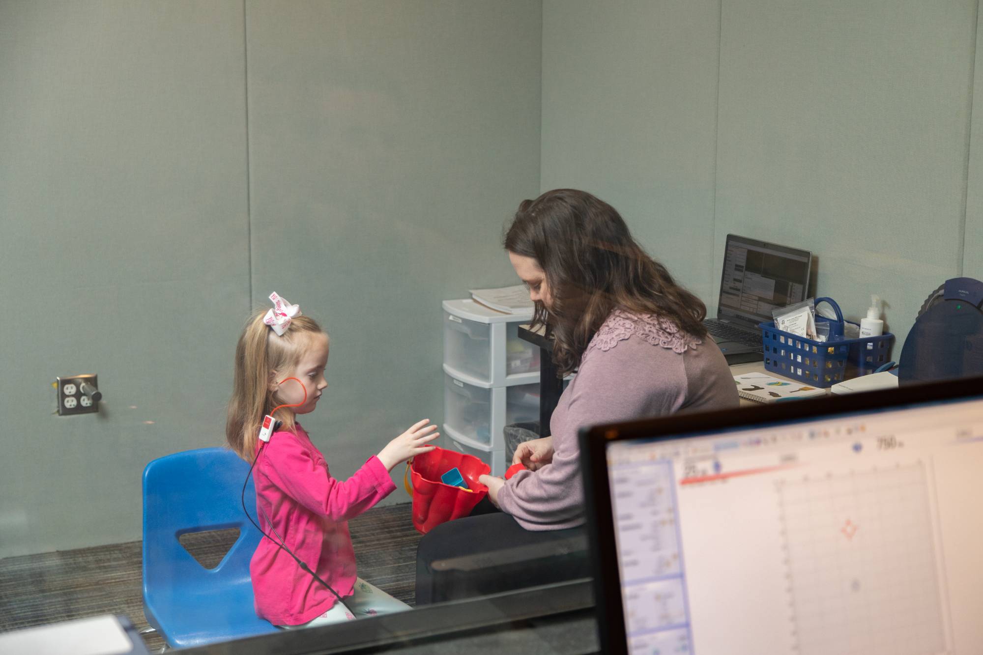 Audiology student performing test with small child